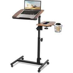 a laptop computer sitting on top of a wooden table next to a black metal stand