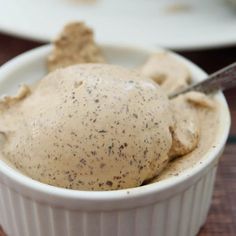 a white bowl filled with ice cream on top of a wooden table