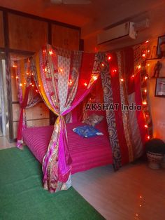 a bedroom decorated in pink and gold with lights on the ceiling, bedding and curtains