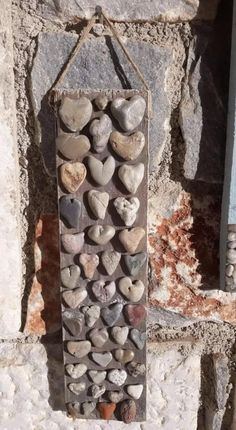 a stone wall with hearts hanging from it