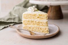 a piece of cake with white frosting on a plate and a fork next to it