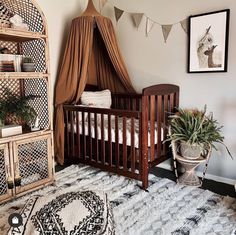 a baby's room with a bed, crib and potted plants