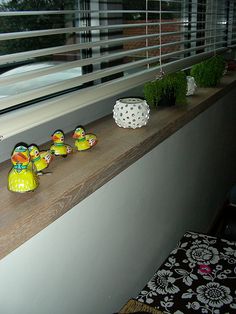 some little ducks are sitting on the window sill