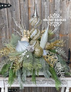 a christmas centerpiece with silver and gold ornaments