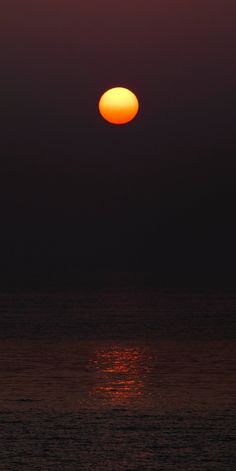 the sun is setting over the ocean with no clouds in sight, and it appears to be very bright