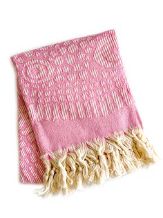 a pink and white towel with fringes on it