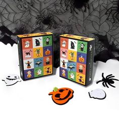 two halloween themed boxes sitting next to each other on a white surface with black lace