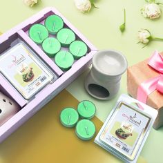 some candles are sitting in a box on a table next to flowers and a card