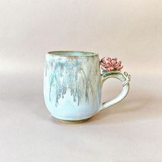 a ceramic mug with a flower on the handle