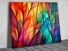 an abstract painting on the wall with colorful leaves in bright colors and white concrete flooring