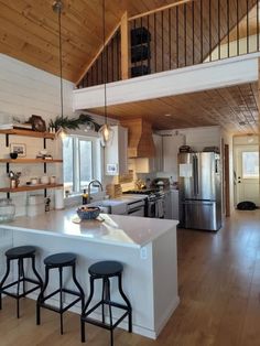 a kitchen with an island and three stools in front of the counter top area