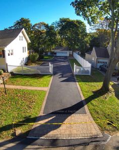 an aerial view of a residential street with houses in the background