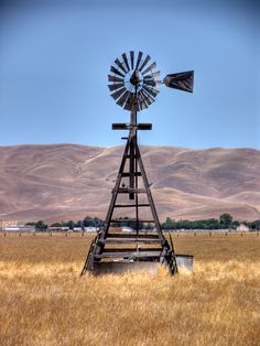 a windmill sitting in the middle of a field