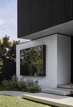 a white brick house with black shutters on the windows