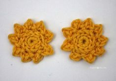 two yellow crocheted flowers sitting next to each other