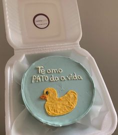 a cake in a box with a rubber ducky on the front and spanish writing on the back