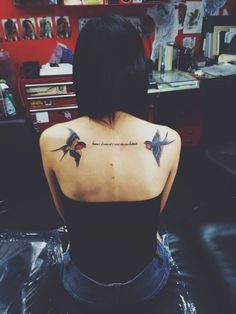 the back of a woman's shoulder with birds on it