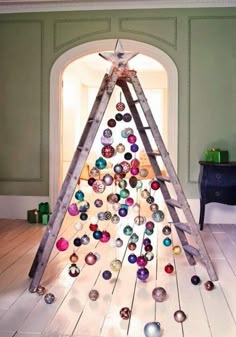 a christmas tree made out of wooden ladders with ornaments hanging from the top and bottom