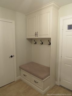 a room with white cabinets and a bench