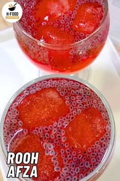 two glasses filled with red liquid sitting on top of a white countertop next to each other