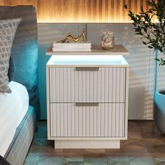 a night stand with two drawers next to a bed and potted plant on the side