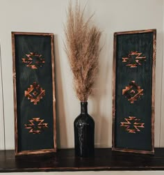 there are two vases with dried grass in them on the shelf next to each other