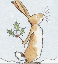 a brown and white rabbit holding a holly berry in its mouth while standing on it's hind legs