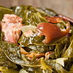 a close up of a plate of food with greens and meat on it, including collard greens