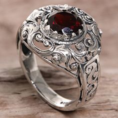 Designed and crafted by Indonesian artisan Agung Jagra this ring features a 2.5 carat garnet. Sterling silver leaf and swirl designs outline the faceted stone and twist down the side of the ring's band. Skull Spider, Sterling Silver Garnet Ring, Seventies Fashion, Fashion Skirts, Garnet Jewelry, Garnet Ring, Wide Band Rings, Filigree Ring, Silver Rings Handmade