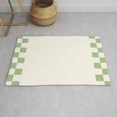 a green and white checkered rug on the floor next to a basket with a plant in it