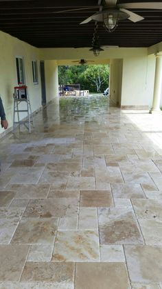 a man is standing in the middle of a room with tile floors and ceiling fans