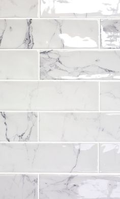 a white marble tile wall that looks like it is being used as a backsplash