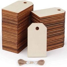 a stack of wooden tags with tassels next to it