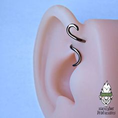 an ear is shown with a black metal spiral on the top and bottom part of it