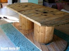 a table made out of wooden boards sitting on top of a blue carpeted floor