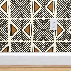 an electrical outlet in front of a patterned wall