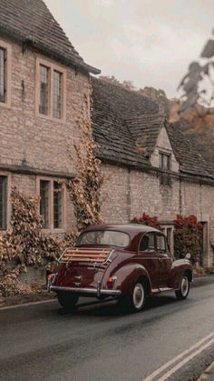 an old car is parked on the side of the road in front of some houses