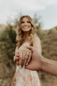 a woman holding the hand of a man who is smiling at her with both hands