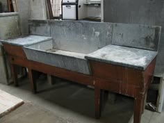 an old metal sink sitting in the middle of a room