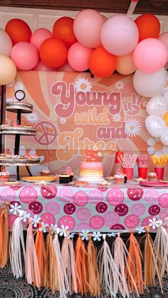 a table topped with lots of cake and balloons