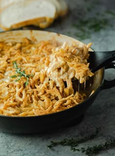 a skillet filled with shredded cheese and bread