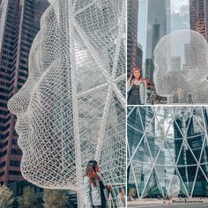 a woman standing next to a giant sculpture in the middle of a city with tall buildings