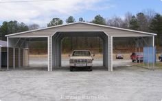 a truck is parked in a carport next to two garages