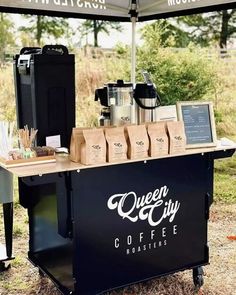 the queen city coffee roaster is set up under an umbrella