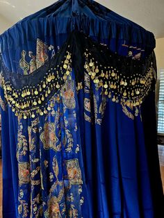 a blue curtain with gold beading on it