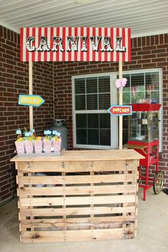 a wooden cart with cupcakes on it in front of a brick building that says carnival