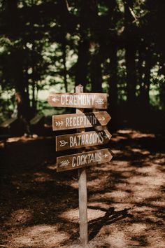 a wooden sign pointing to various destinations in the woods