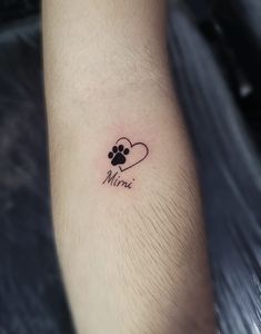 a dog paw with a heart tattoo on the ankle that reads mimie and is written in black ink