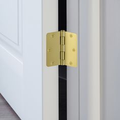 a close up of a door handle on a white door with black and gold trim