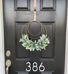 a black front door with a wreath and numbers on it